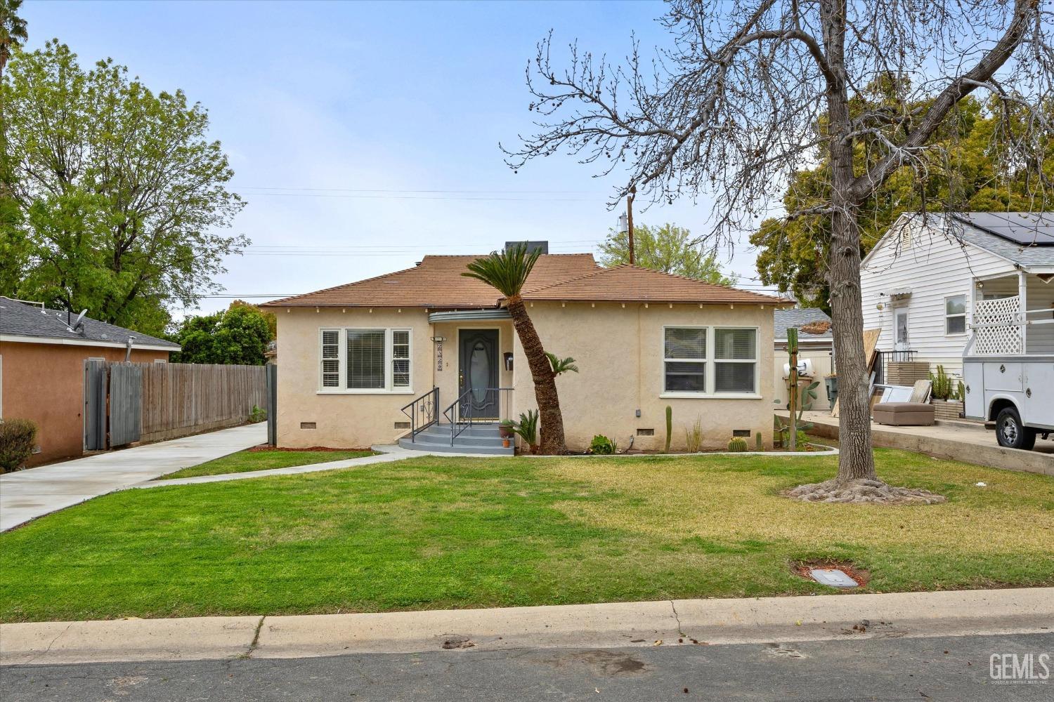 Undisclosed Address Bakersfield, CA 93305 - Photo 9 of 46 a front view of a house with a yard and garage