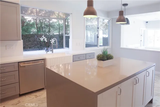 a kitchen with a sink a large window and a granite counter top