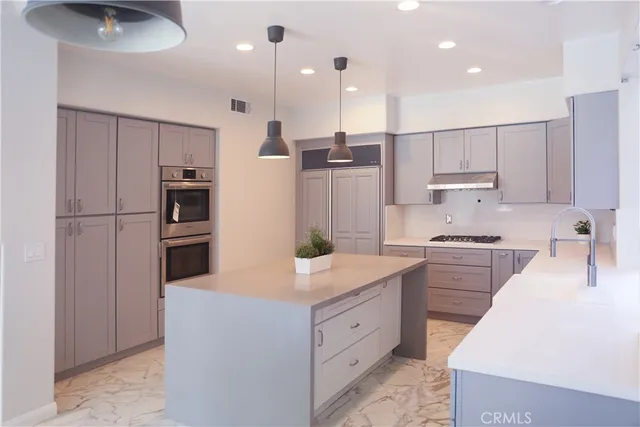 a kitchen with kitchen island a sink stainless steel appliances and cabinets
