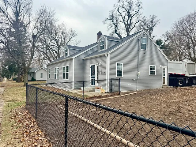 a view of a house with backyard and sitting area