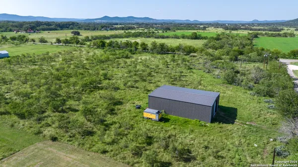 a view of a lush green field with a house in the background