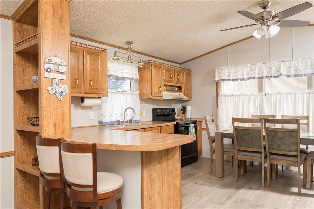 405 Cory Drive Mission, TX 78572 - Photo 5 of 13 a kitchen with kitchen island granite countertop a table and chairs in it