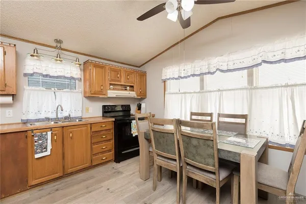 a kitchen with stainless steel appliances granite countertop a stove a sink dishwasher and cabinets with wooden floor