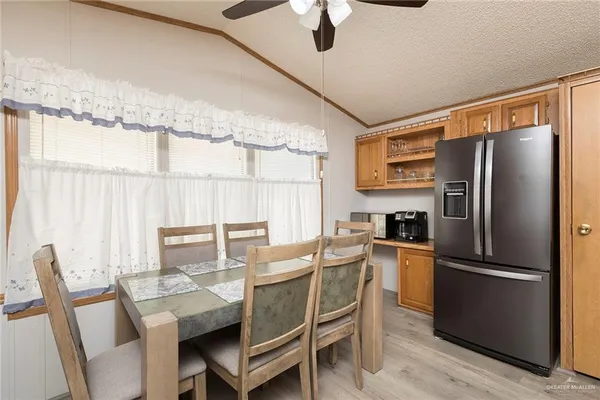 a kitchen with a table chairs refrigerator and microwave