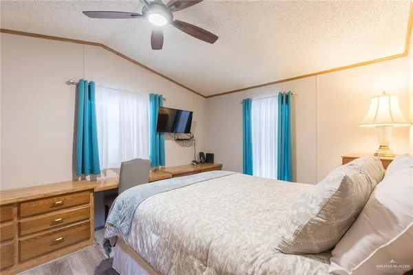 a bedroom with a bed a window and a chandelier