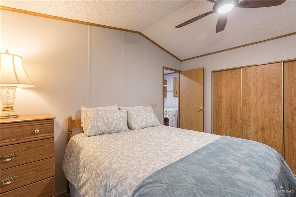 405 Cory Drive Mission, TX 78572 - Photo 9 of 13 a bedroom with a large bed and a chandelier fan