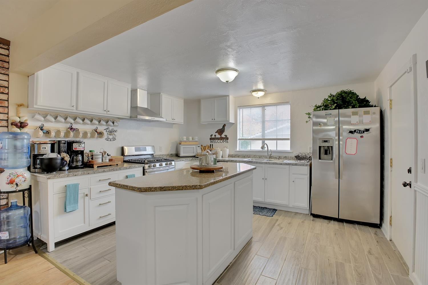 1408 Hazel Street Gridley, CA 95948 - Photo 48 of 60 a kitchen with a sink a stove a refrigerator and white cabinets