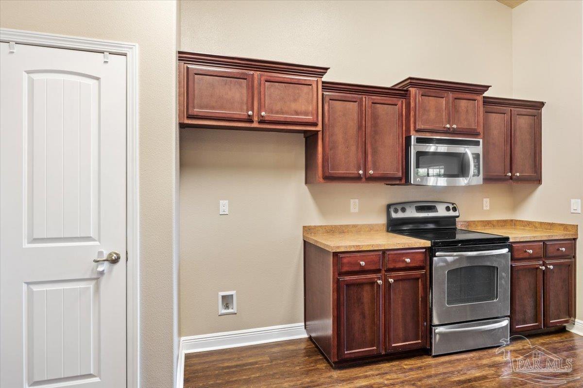 4015 Berry Circle Pace, FL 32571 - Photo 13 of 48 a kitchen with wooden cabinets and a stove top oven