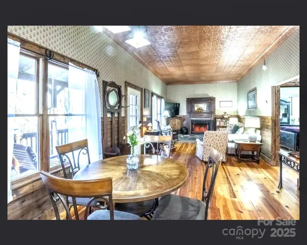 a table with a vase and a glass of wine sitting on a table