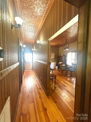 a view of a dining room with furniture a chandelier and wooden floor