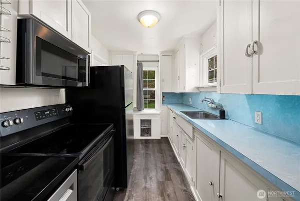 a kitchen with a sink stove and microwave
