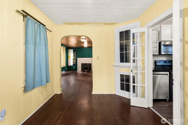 a view of a hallway with wooden floor and dining room