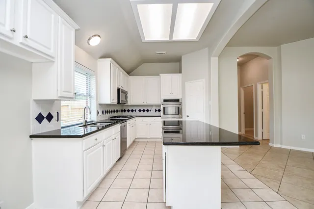 a large kitchen with cabinets and stainless steel appliances
