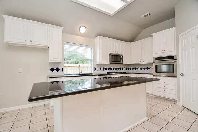 a kitchen with stainless steel appliances granite countertop a sink and a stove