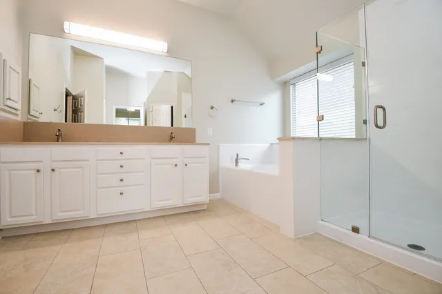 a spacious bathroom with a granite countertop sink a mirror and a