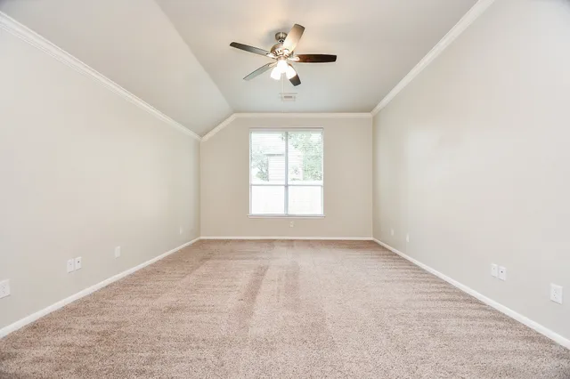 an empty room with a window and a ceiling fan