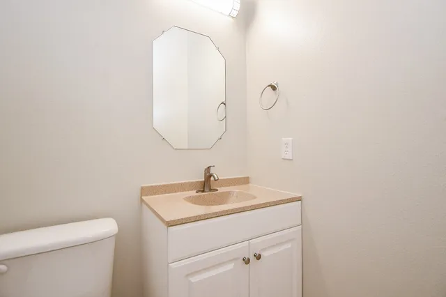 a bathroom with a sink a toilet and a mirror