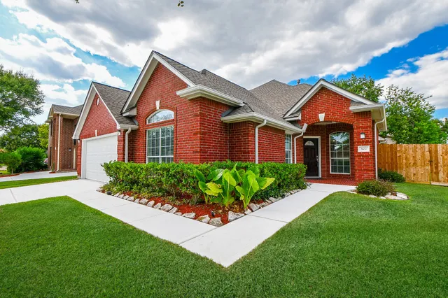 a front view of a house with a yard and potted plants