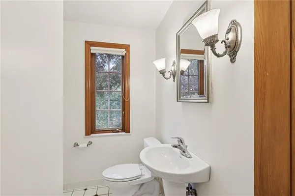 a bathroom with a toilet a sink and mirror