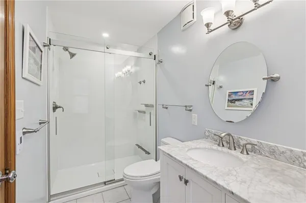 a bathroom with a granite countertop sink toilet and shower