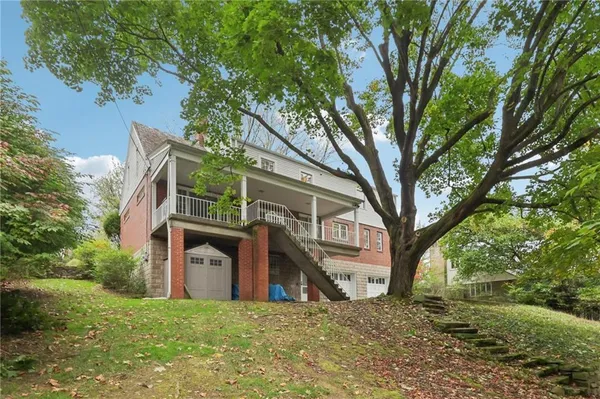 a view of a house with a large tree