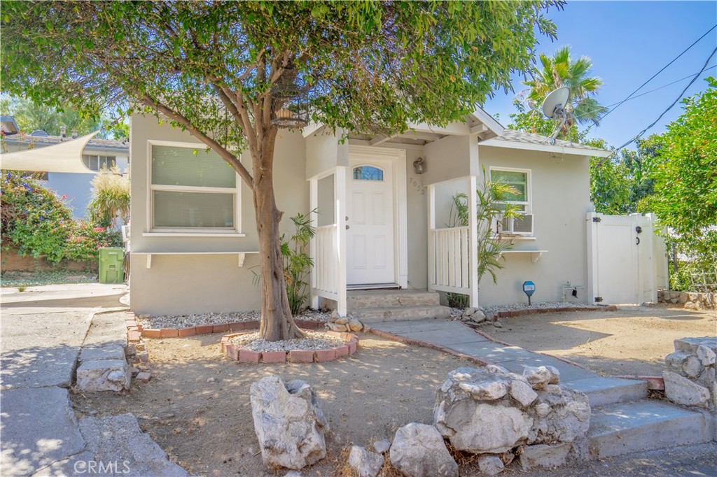 a view of a house with backyard and a tree