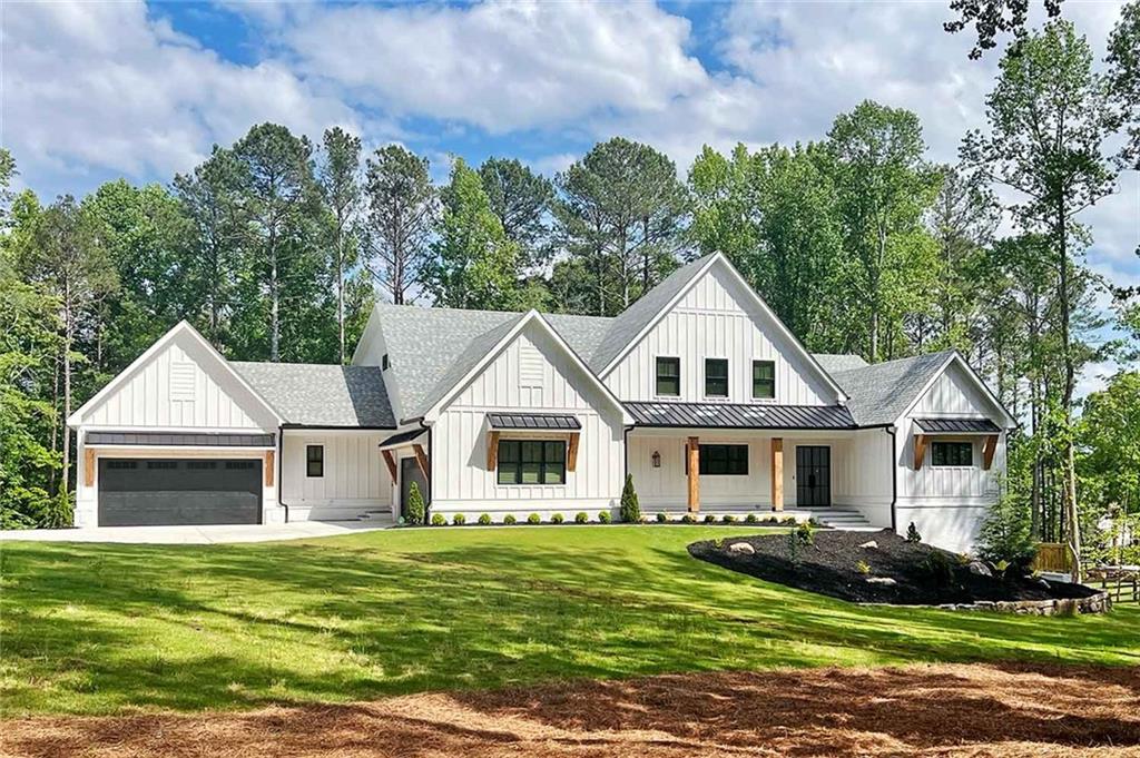 a view of a yard in front of a house with plants and large tree