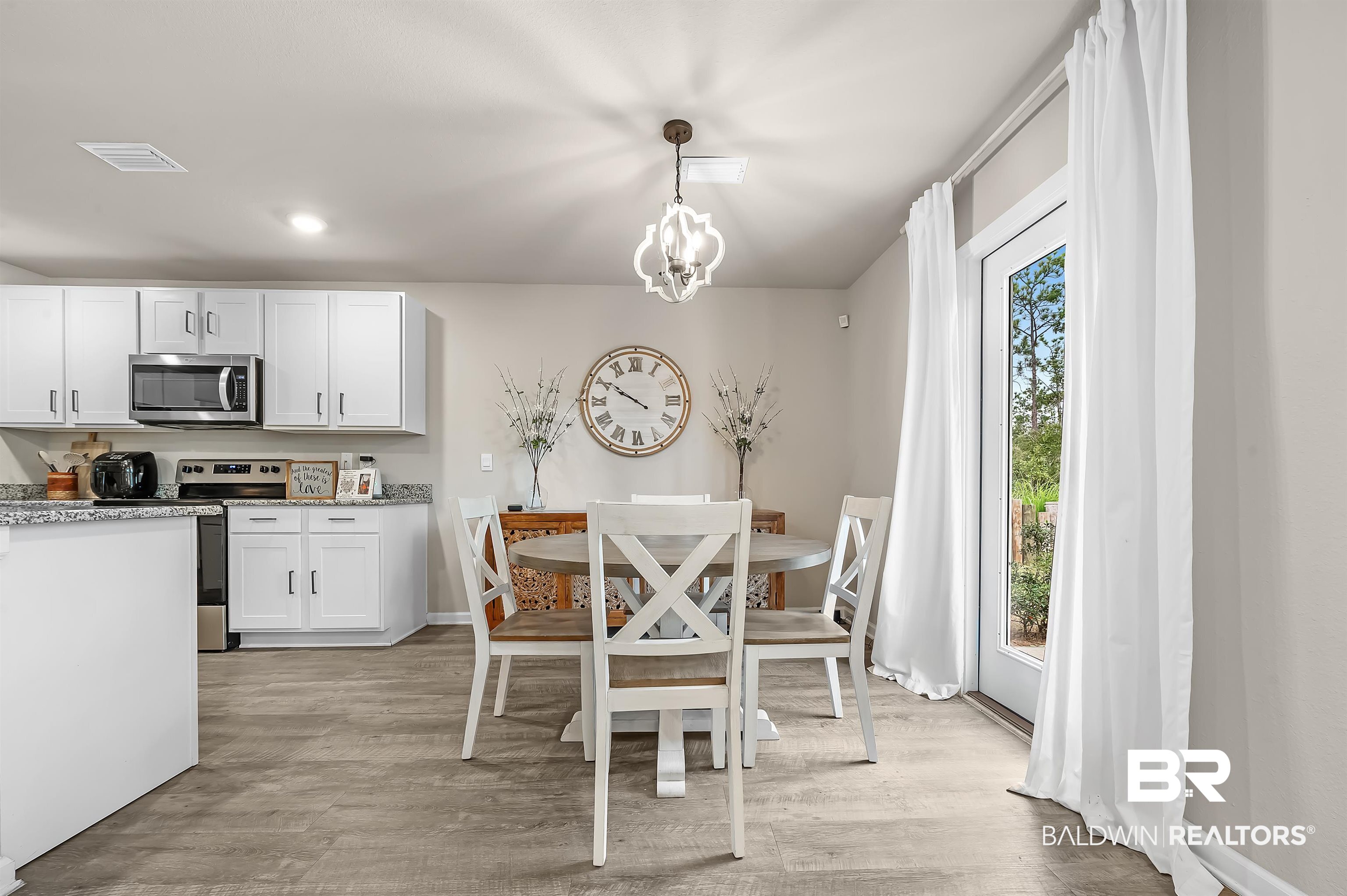 24549 Broken Sound Loop Orange Beach, AL 36561 - Photo 19 of 57 Dining area featuring light hardwood / wood-style flooring, a chandelier, and a healthy amount of sunlight