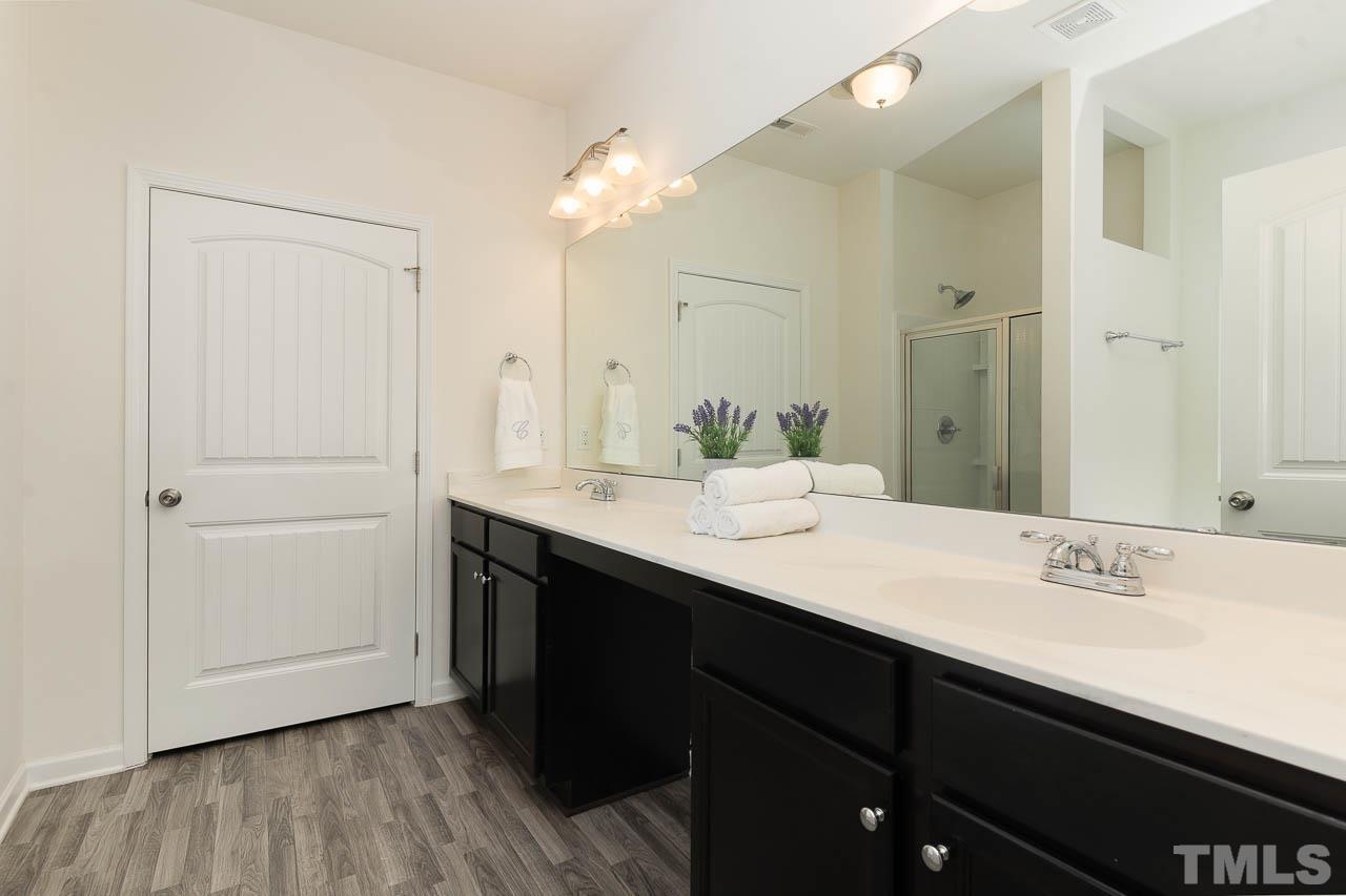 6809 Shane Drive Raleigh, NC 27610 - Photo 16 of 21 a bathroom with a double vanity sink a mirror and shower