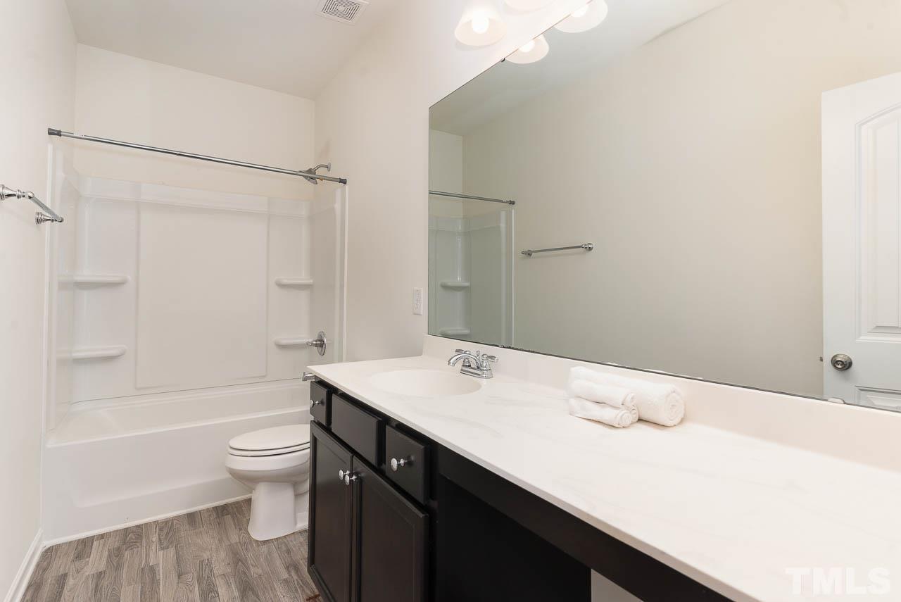 6809 Shane Drive Raleigh, NC 27610 - Photo 20 of 21 a bathroom with a sink a toilet and shower