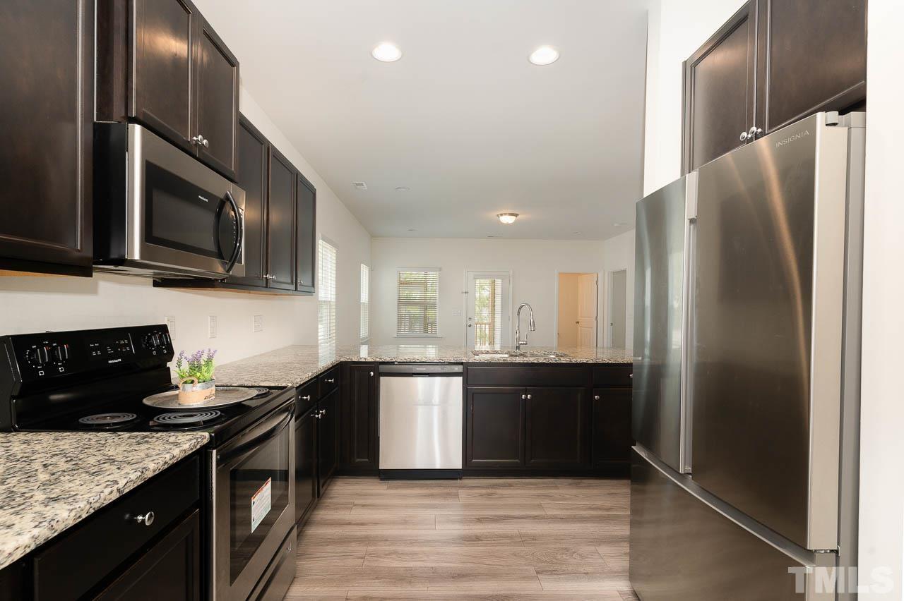 6809 Shane Drive Raleigh, NC 27610 - Photo 6 of 21 a kitchen with stainless steel appliances granite countertop a refrigerator a stove a sink and a microwave