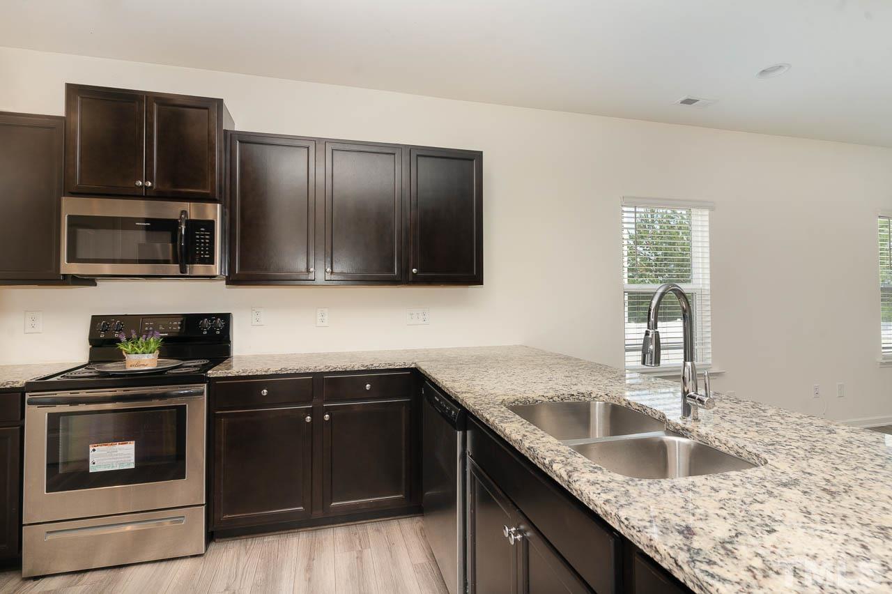 6809 Shane Drive Raleigh, NC 27610 - Photo 7 of 21 a kitchen with granite countertop a sink and steel appliances