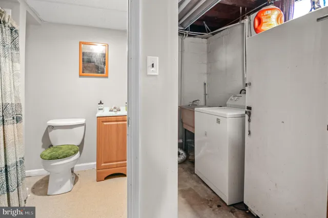 a white toilet sitting next to a bathroom sink and vanity