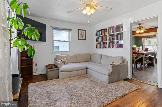 a living room with furniture a chandelier and a dining table