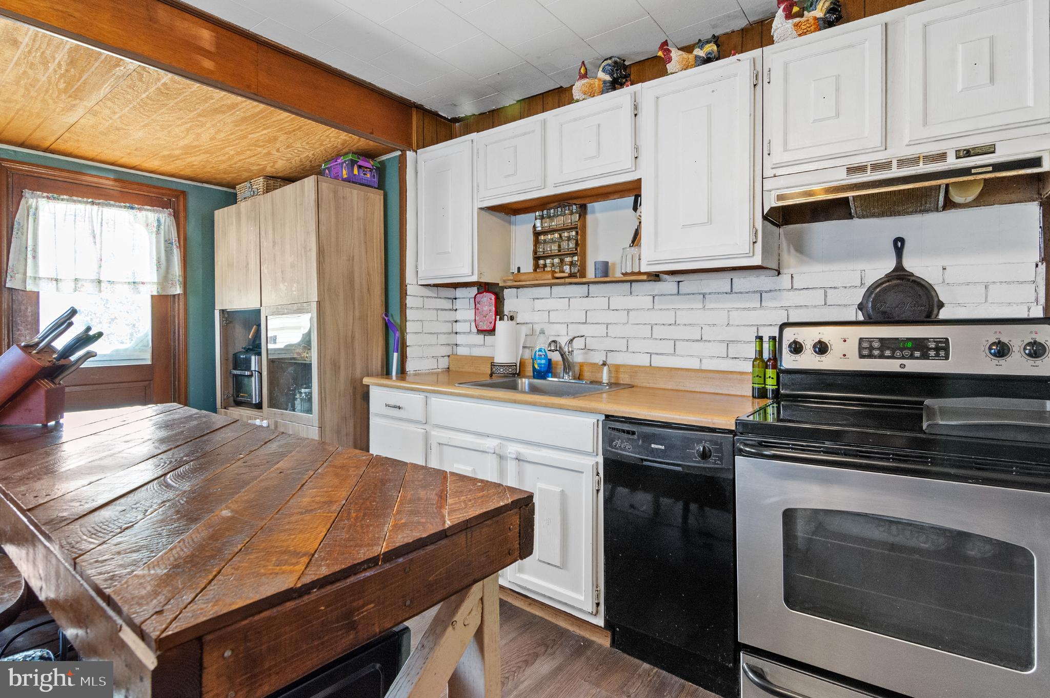 3 Compression Court Middle River, MD 21220 - Photo 8 of 27 a kitchen with stainless steel appliances a stove a sink dishwasher and cabinets with wooden floor
