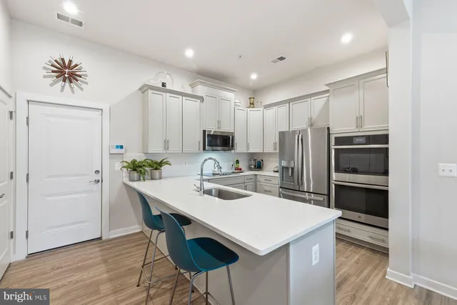 a kitchen with appliances a counter space and cabinets