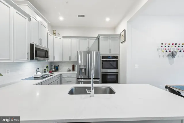 a kitchen with granite countertop a refrigerator sink and microwave