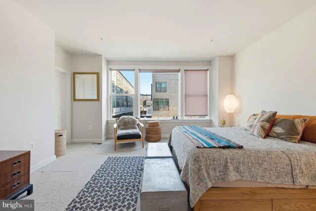 a bedroom with a large bed couch and a window