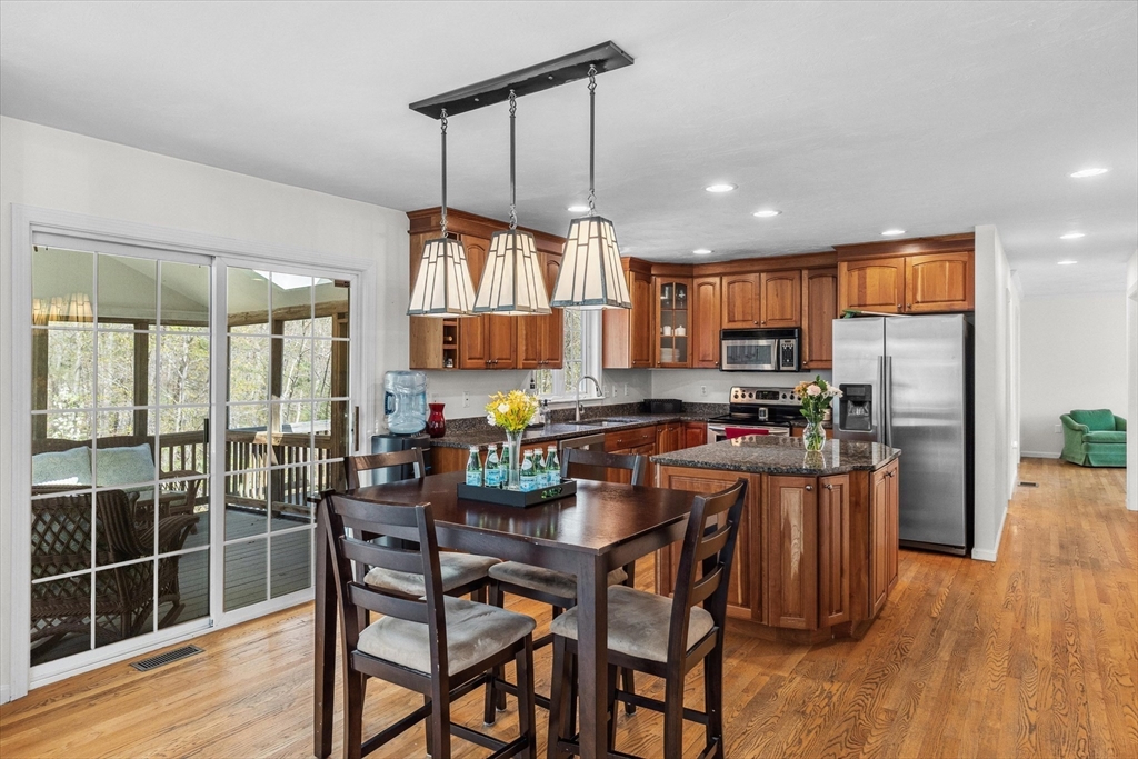 10 Falls Brook Road Hudson, MA 01749 - Photo 12 of 42 a kitchen with stainless steel appliances a dining table chairs refrigerator and microwave