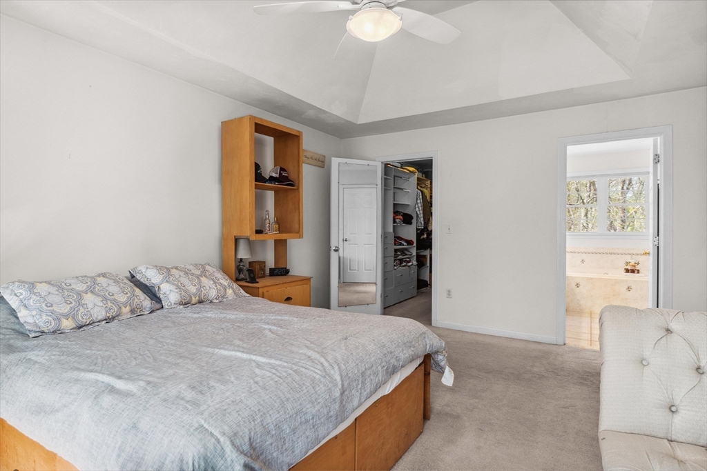 10 Falls Brook Road Hudson, MA 01749 - Photo 28 of 42 a bedroom with a bed and a chandelier