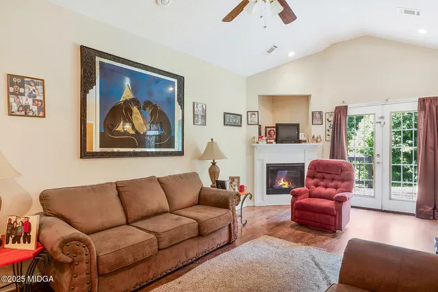 a living room with furniture a fireplace and a large window