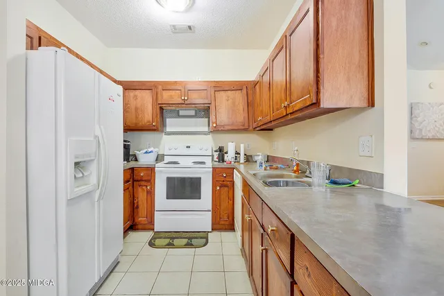 a kitchen with a stove sink and cabinets