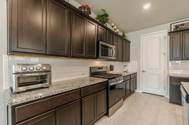 a large kitchen with a large counter top appliances and cabinets