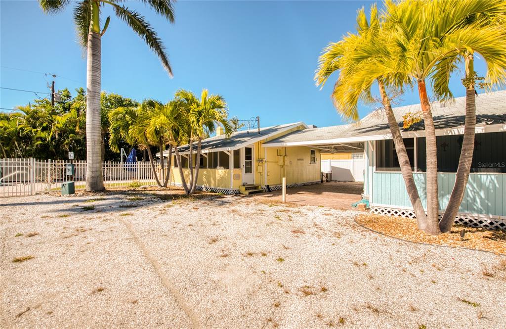13136 4th Street East Madeira Beach, FL 33708 - Photo 15 of 75 a view of a house with a tree and wooden fence
