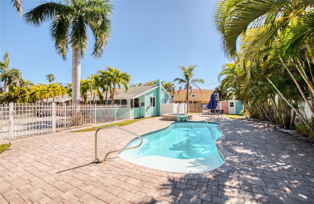 13136 4th Street East Madeira Beach, FL 33708 - Photo 22 of 75 a view of a swimming pool with a yard and palm trees