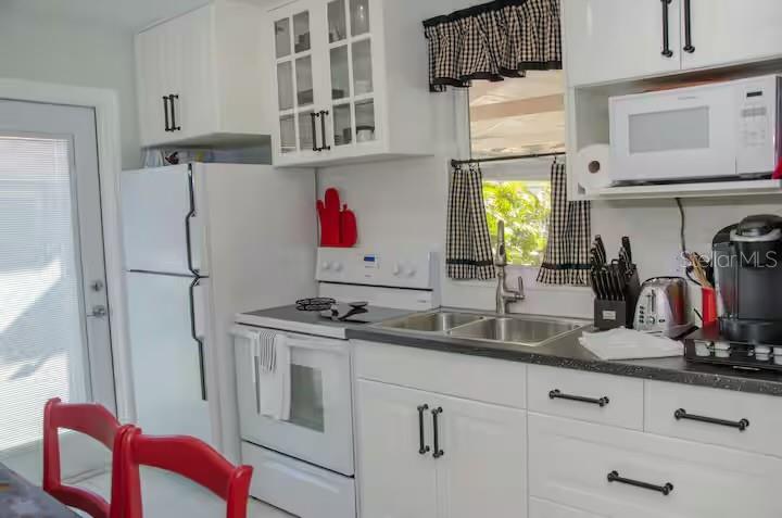 13136 4th Street East Madeira Beach, FL 33708 - Photo 45 of 75 a kitchen with stainless steel appliances granite countertop a refrigerator and a sink