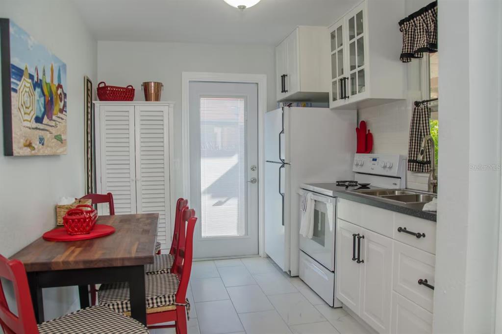 13136 4th Street East Madeira Beach, FL 33708 - Photo 46 of 75 a kitchen with stainless steel appliances granite countertop a refrigerator and a stove