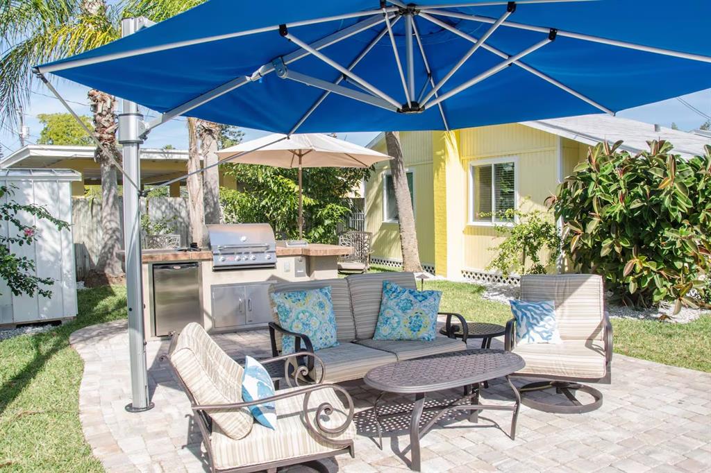 13136 4th Street East Madeira Beach, FL 33708 - Photo 50 of 75 a patio with a table and chairs under an umbrella