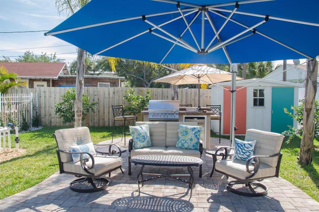 13136 4th Street East Madeira Beach, FL 33708 - Photo 51 of 75 a patio with a table and chairs under an umbrella