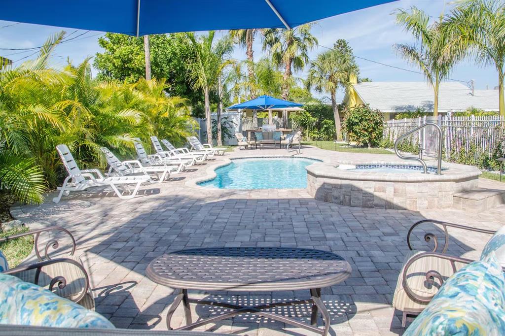 13136 4th Street East Madeira Beach, FL 33708 - Photo 56 of 75 a view of a patio with table and chairs potted plants